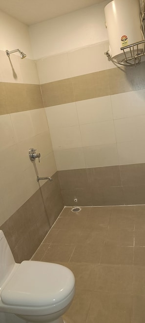 A bathroom with a toilet, a shower, and a towel rack.