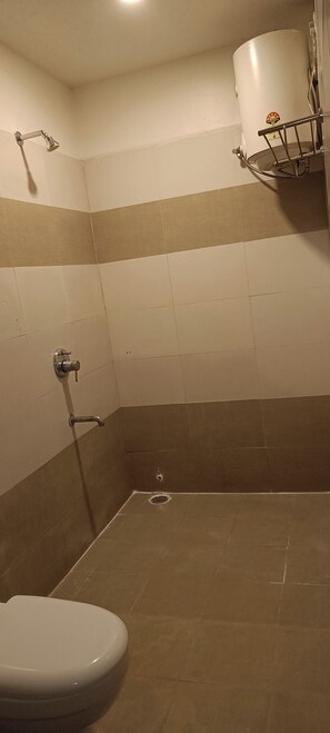 A bathroom with a toilet, a shower, and a sink.