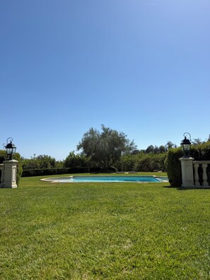 A swimming pool surrounded by a well-maintained lawn, with two lamp posts on either side. - 2-bedroom Guest House European estate in  Somis perfect for relaxing getaway (Somis)