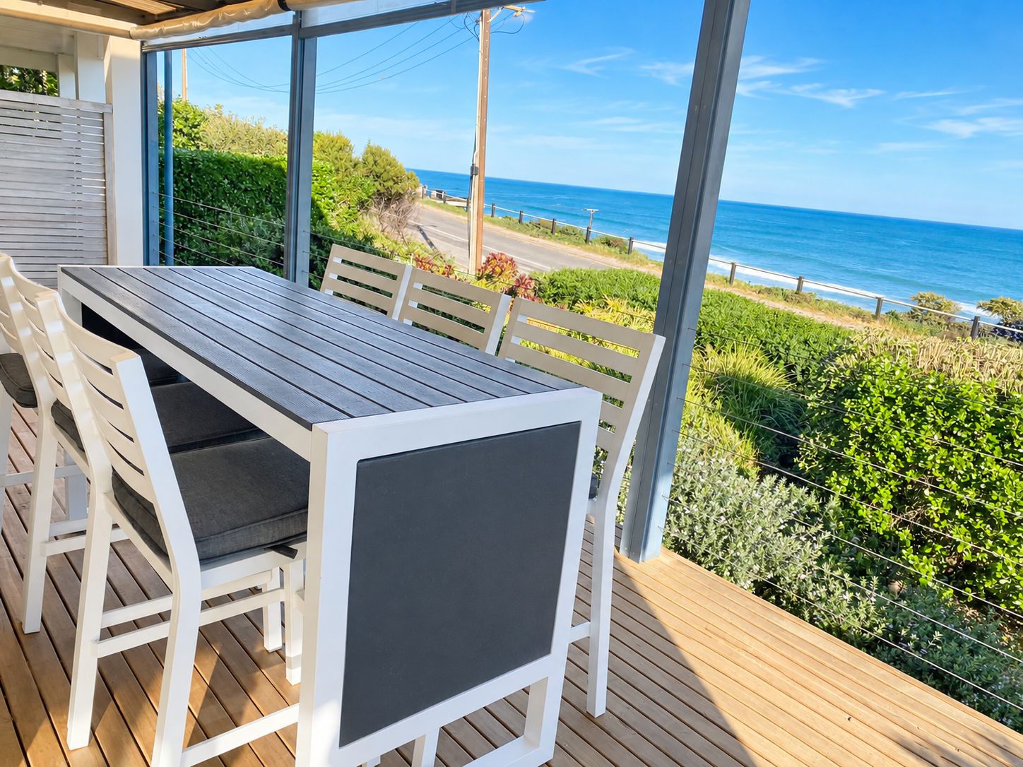 A covered outdoor seating area with a view of the ocean.