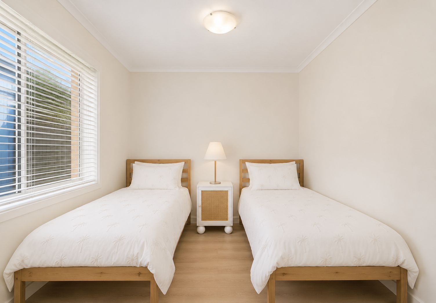 Bright twin bedroom with natural light and crisp, minimalist style