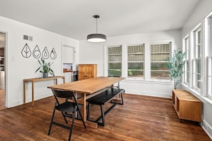 A modern kitchen with a wooden table, chairs, and a pendant light. - Hilltop Charm — 4BR house in Menomonie (Menomonie)