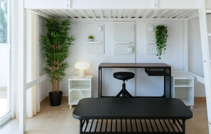 A modern, minimalist room with a black bench, white shelving, and a potted plant. - Lovely apartment in Santa Cruz de Tenerife with WiFi (Santa Cruz de Tenerife)