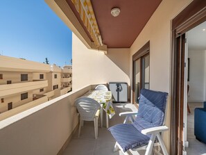 Ein Balkon mit Tisch, Stühlen und einem Kühlschrank.