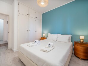 Ein Hotelzimmer mit Bett, Schrank, Nachttisch und Lampe.