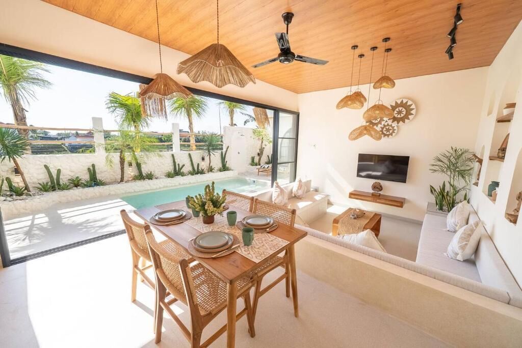 A modern interior with a dining area, a pool, and a living space with a TV.