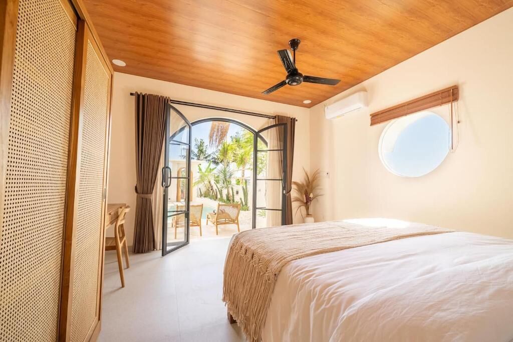 A bedroom with a bed, a ceiling fan, a window, and a view of the outdoors.