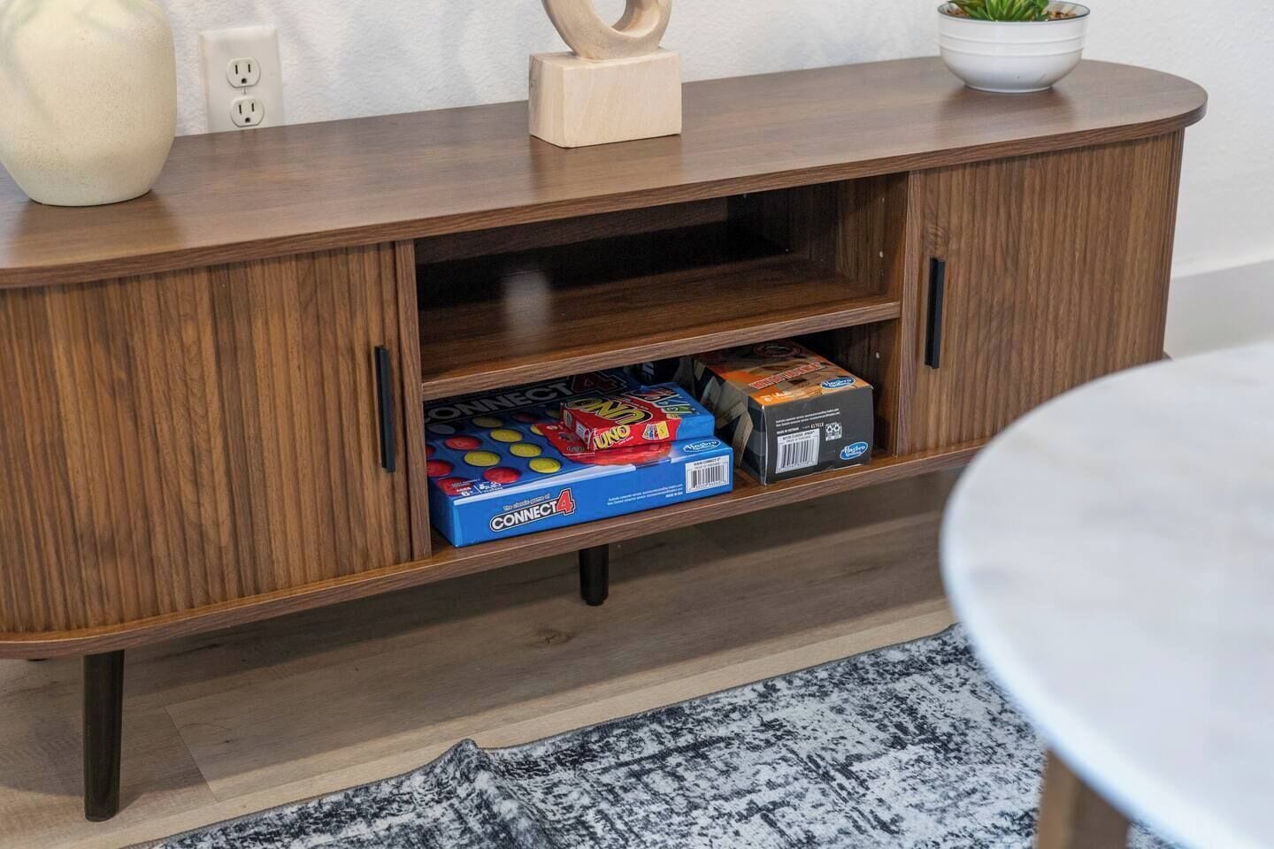 Ett träskåp med en låda som innehåller Connect 4-spel och ett Connect 4-spel.