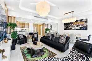Ein modernes Wohnzimmer mit einem schwarzen Sofa, einem Couchtisch und einer Chandelier.