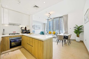 Una cucina moderna con isola centrale, forno integrato e zona pranzo con vista sulla città.