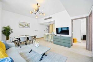 A modern living room with a dining area, a kitchen, and a TV. - LIV Marina 2BR · City View · Beach 5min (Dubai)