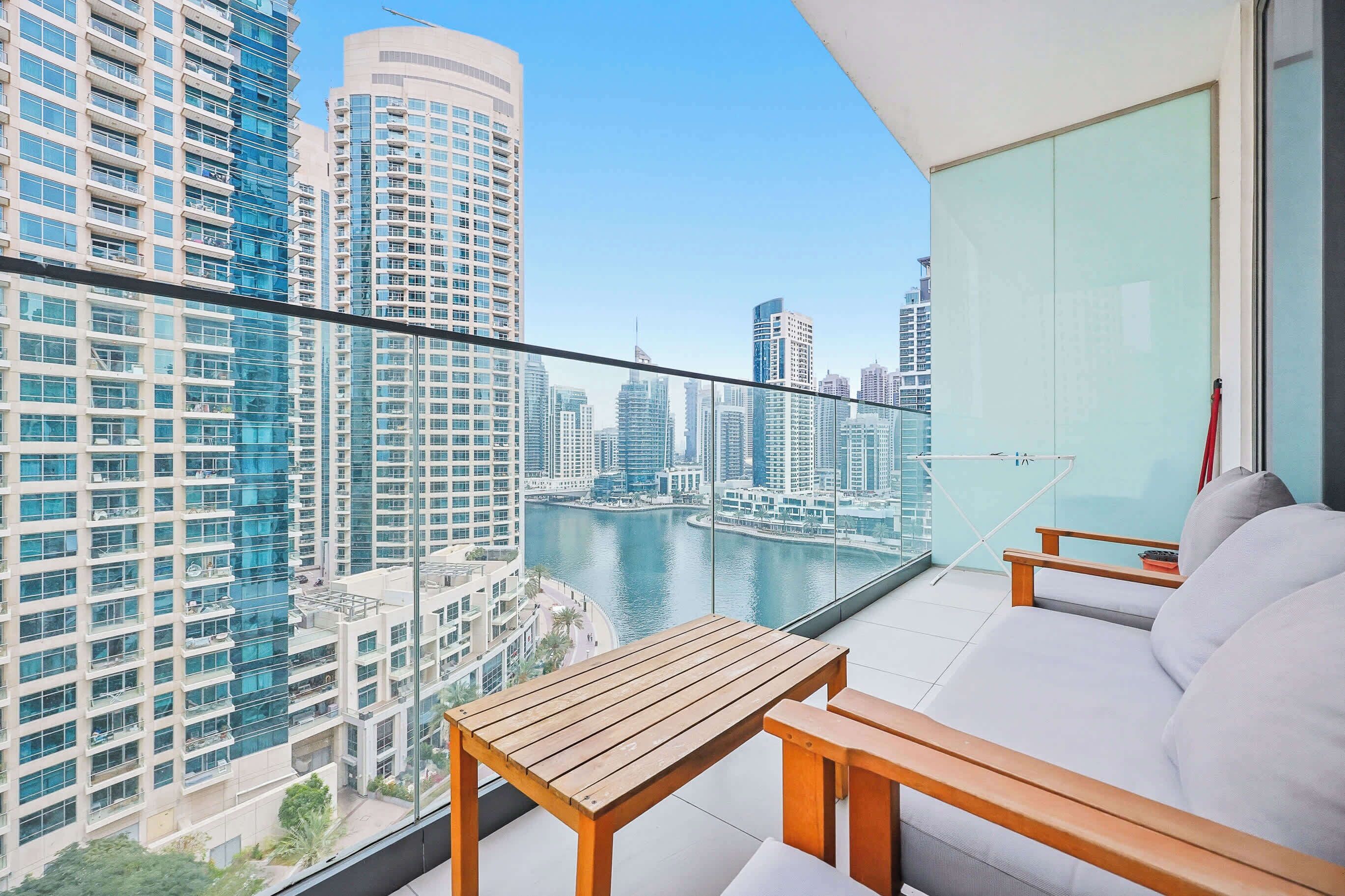 A balcony with a view of a cityscape and a body of water.