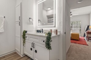 A modern bathroom with a white vanity, a large mirror, and a towel rack. - Near NRG Stadium & DT| Pool & Gym, Free Parking (Houston)