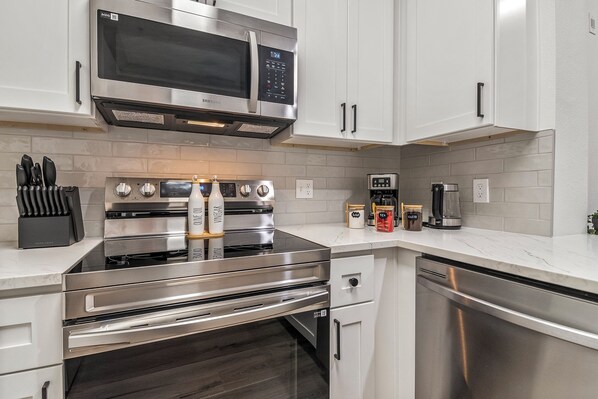 A modern kitchen with stainless steel appliances, including a microwave, oven, and coffee maker.