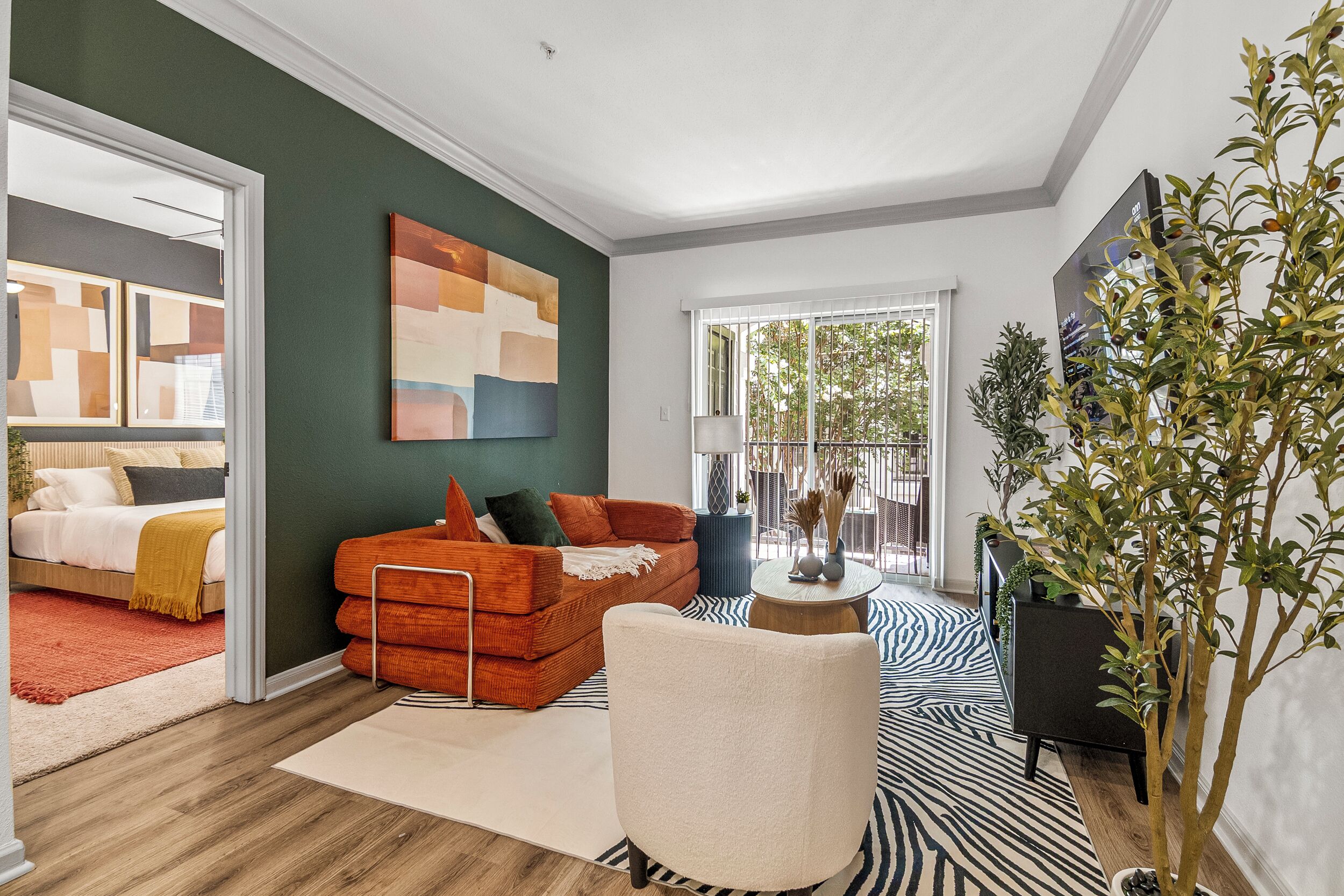 A modern living room with a sofa, a chair, a coffee table, and a large window.