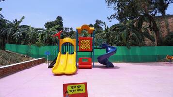 A playground with a yellow slide, a blue slide, and a climbing structure.