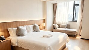 A hotel room with a large bed, bedside tables, a desk, a window with curtains, and a view of the city. - Ebony Hotel (Douala)