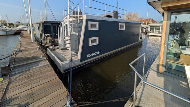 A boat docked at a marina with a wooden deck and a glass viewing area. - Unique Houseboat near Amsterdam (20 min) (Monnickendam)
