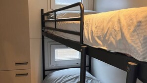 A bunk bed with a window, a small cabinet, and a wicker basket. - Fantastic Houseboat, 15 min Amsterdam Free Parking (Monnickendam)