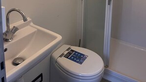 A bathroom with a white sink, toilet, and glass shower enclosure. - Fantastic Houseboat, 15 min Amsterdam Free Parking (Monnickendam)