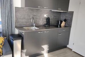 Eine moderne Küche mit integriertem Spülbecken, einer Kaffeemaschine und einem Messerblock.