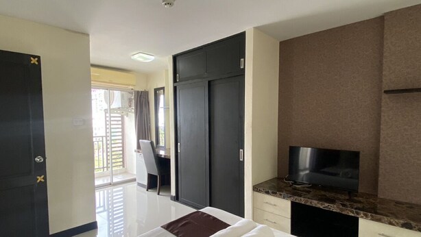 A hotel room with a bed, a TV, a desk, and a wardrobe. - Leelawadee Huaikhwang (Bangkok)
