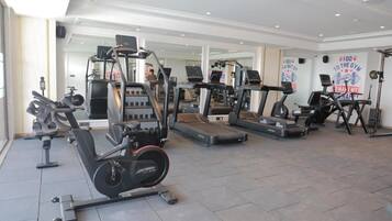 A gym with various exercise equipment including treadmills, an elliptical, and weight machines.