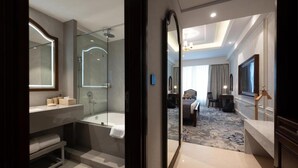 A modern bathroom with a glass-enclosed shower, a bathtub, and a vanity with a mirror.