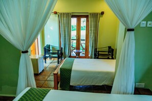 Una camera d'albergo con un letto, una sedia, un tavolo e vista sull'esterno.