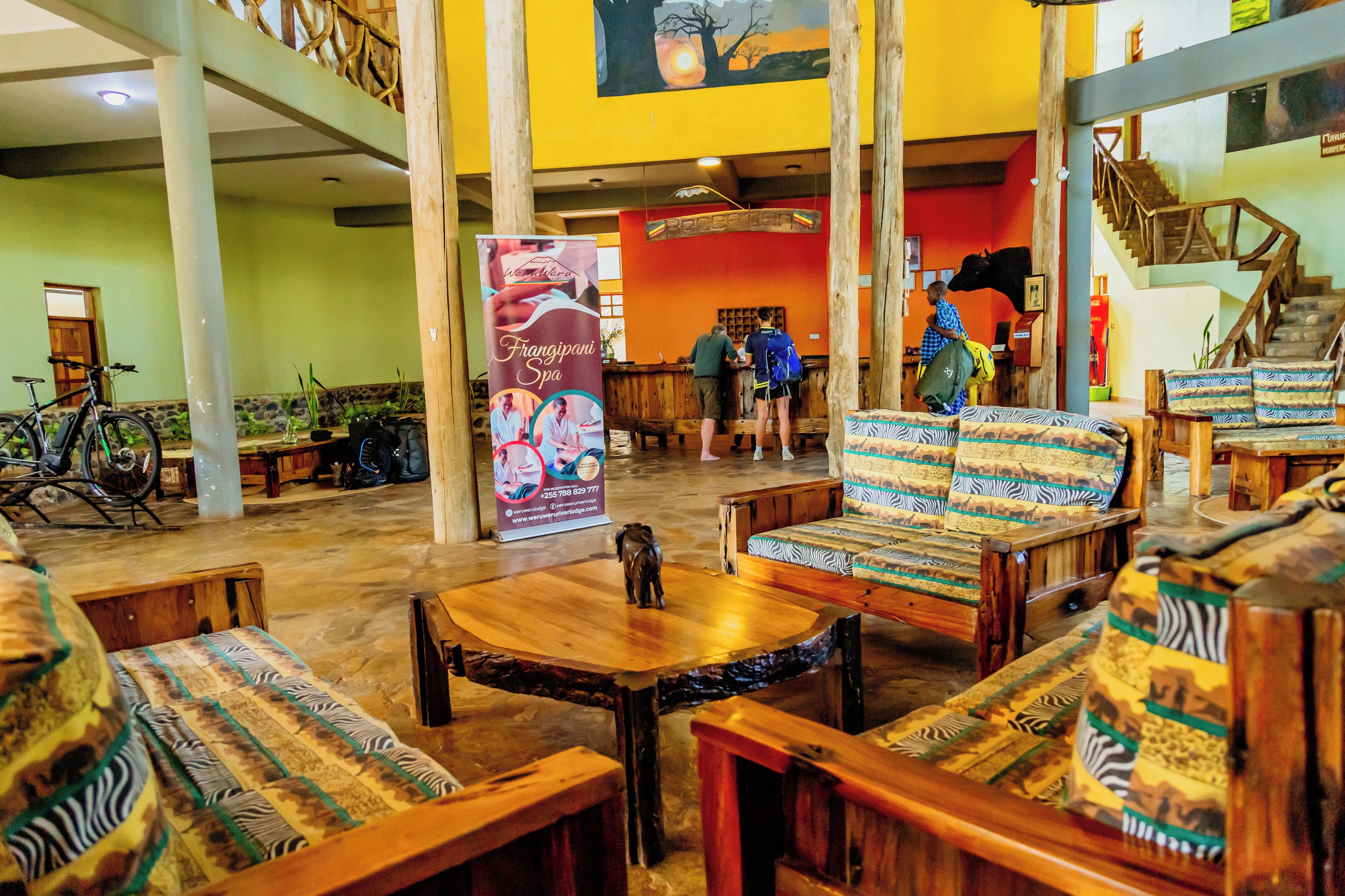 A lobby with wooden furniture, a reception desk, and a staircase.
