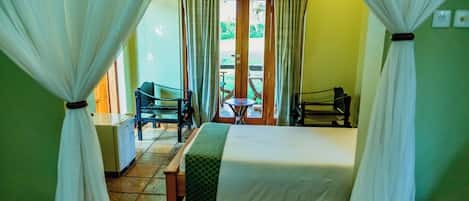 Una habitación de hotel con cama, una silla, una mesa y vistas al exterior.