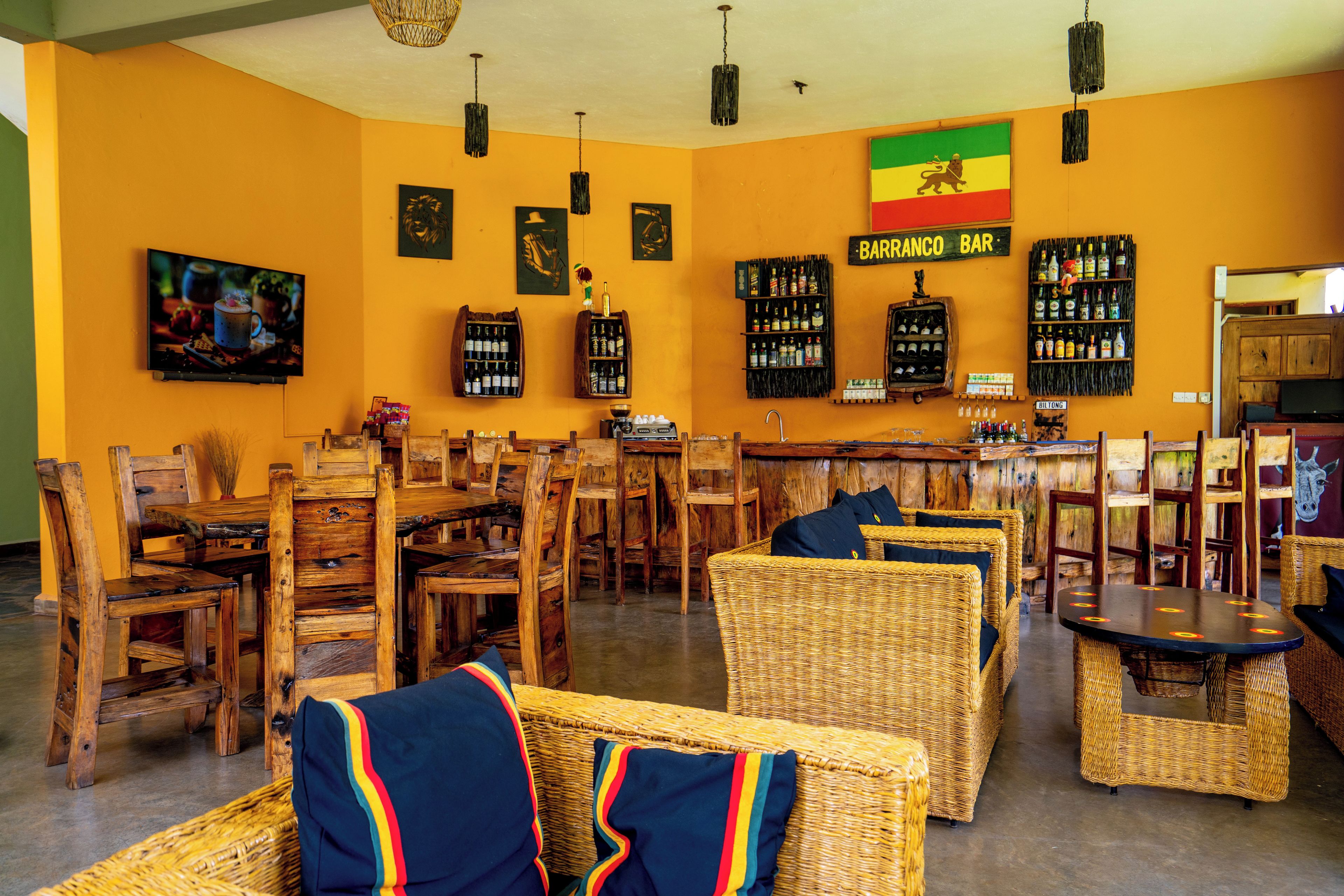 Un área de bar con mobiliario de madera y una bandera en la pared.
