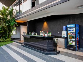 Una zona de bar con mostrador, un refrigerador lleno de bebidas y una máquina expendedora de Pepsi.