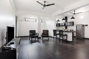 A modern kitchen with dark tiles, a central island, and pendant lighting.