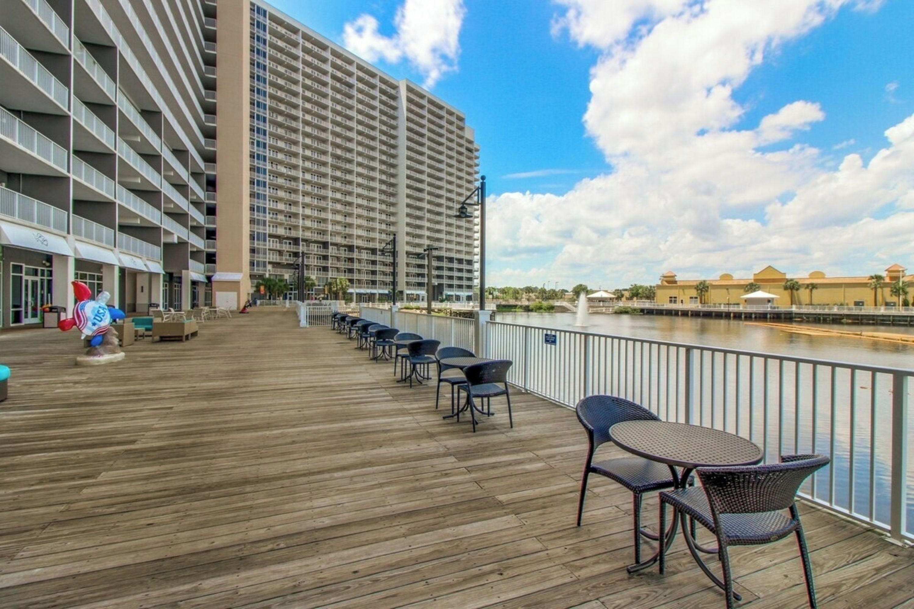 A hotel deck with outdoor seating and a view of a river.