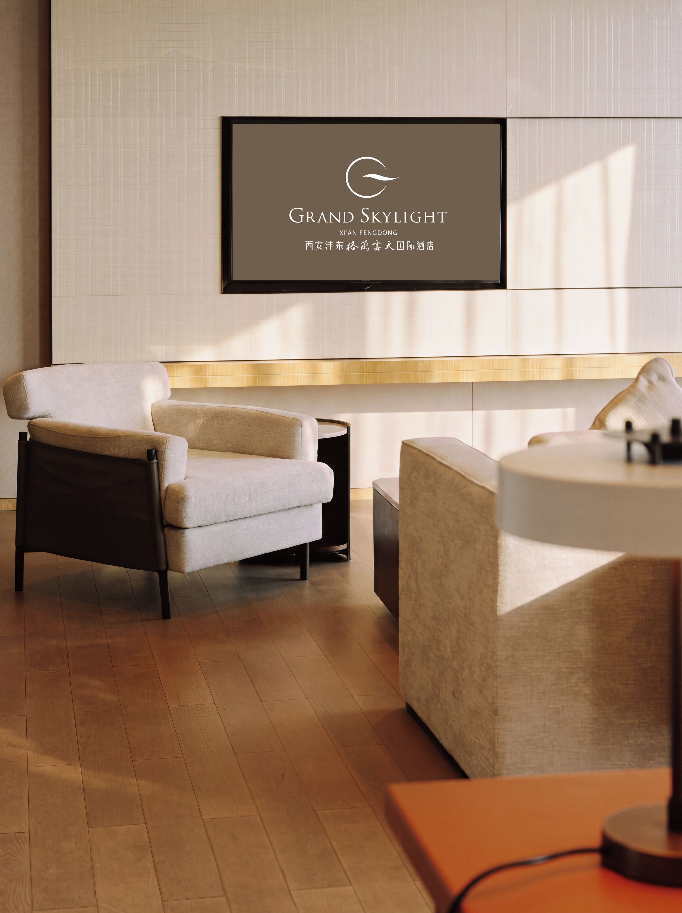 A modern hotel lobby with a reception desk, seating area, and a framed sign above.