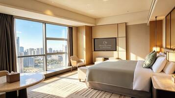 A modern hotel room with a large bed, a seating area, a TV, and a view of the cityscape.