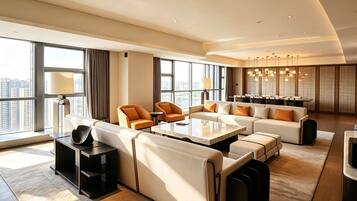 A modern hotel room with a large seating area, a dining table, and large windows offering a city view.
