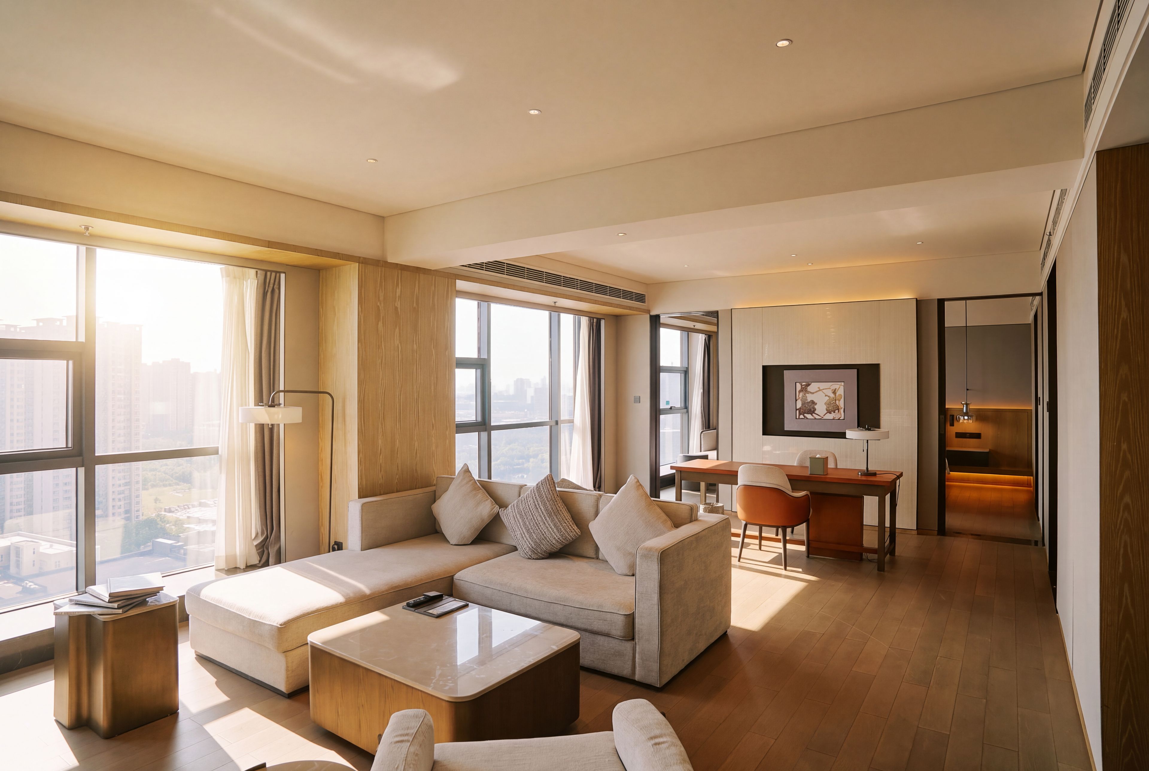 A modern living room with a sectional sofa, a coffee table, and a dining area with a table and chairs.
