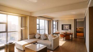 A modern living room with a sectional sofa, a coffee table, and a dining area with a table and chairs.