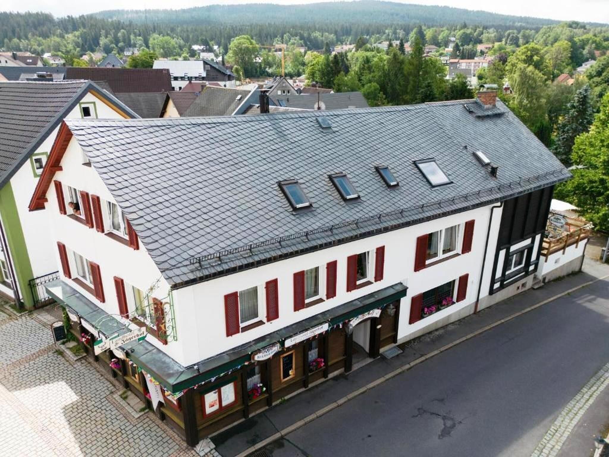 A two-story building with a sloped roof, multiple windows, and a ground-floor commercial space with signage.