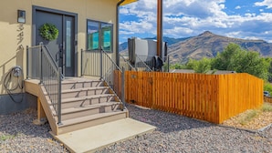 A modern building with a wooden fence, a staircase leading to a door, and a view of mountains in the background. - Hot Tub, Mt Views, Luxury New build in Golden (Golden)