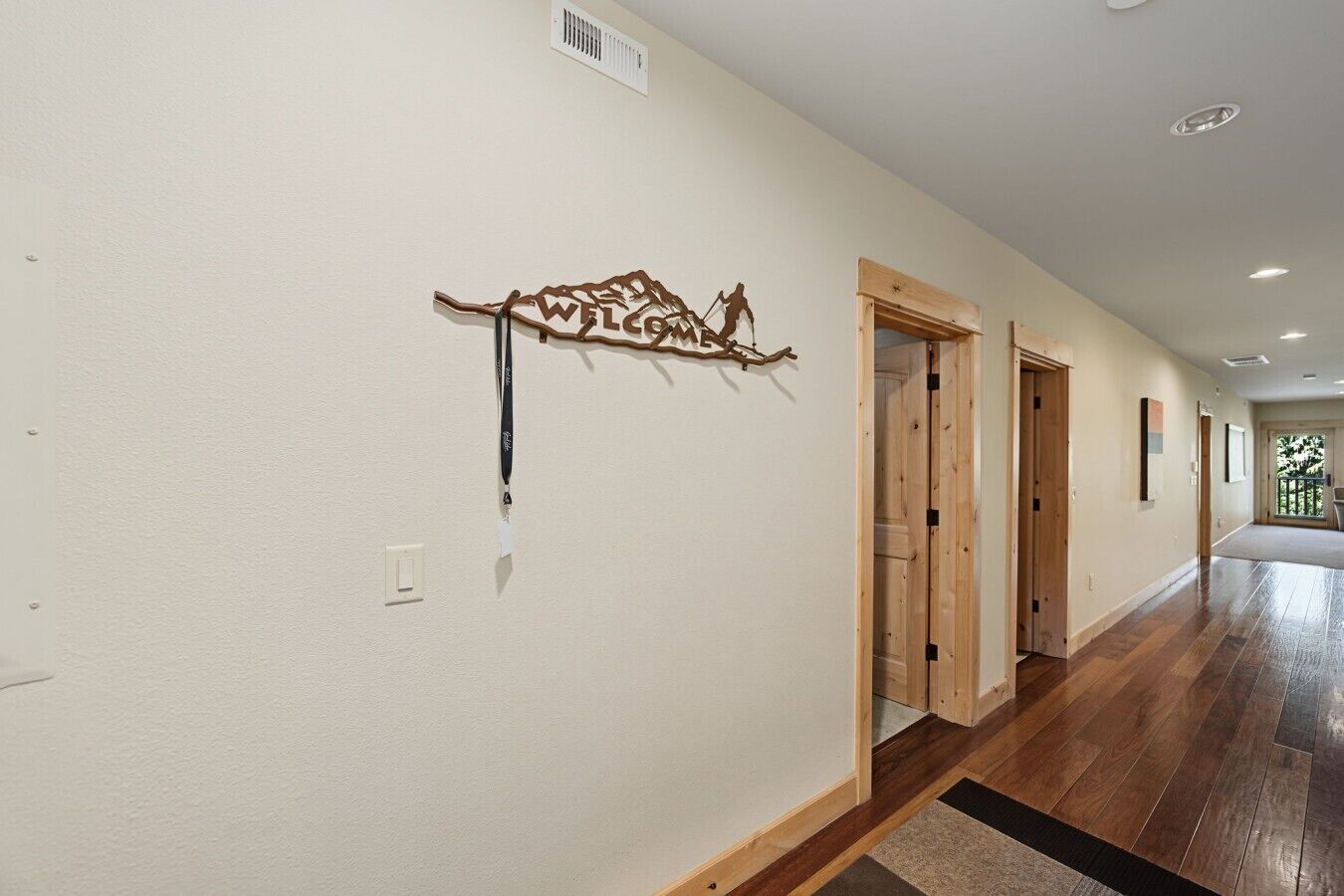 A hallway with wooden doors and a decorative wall piece.
