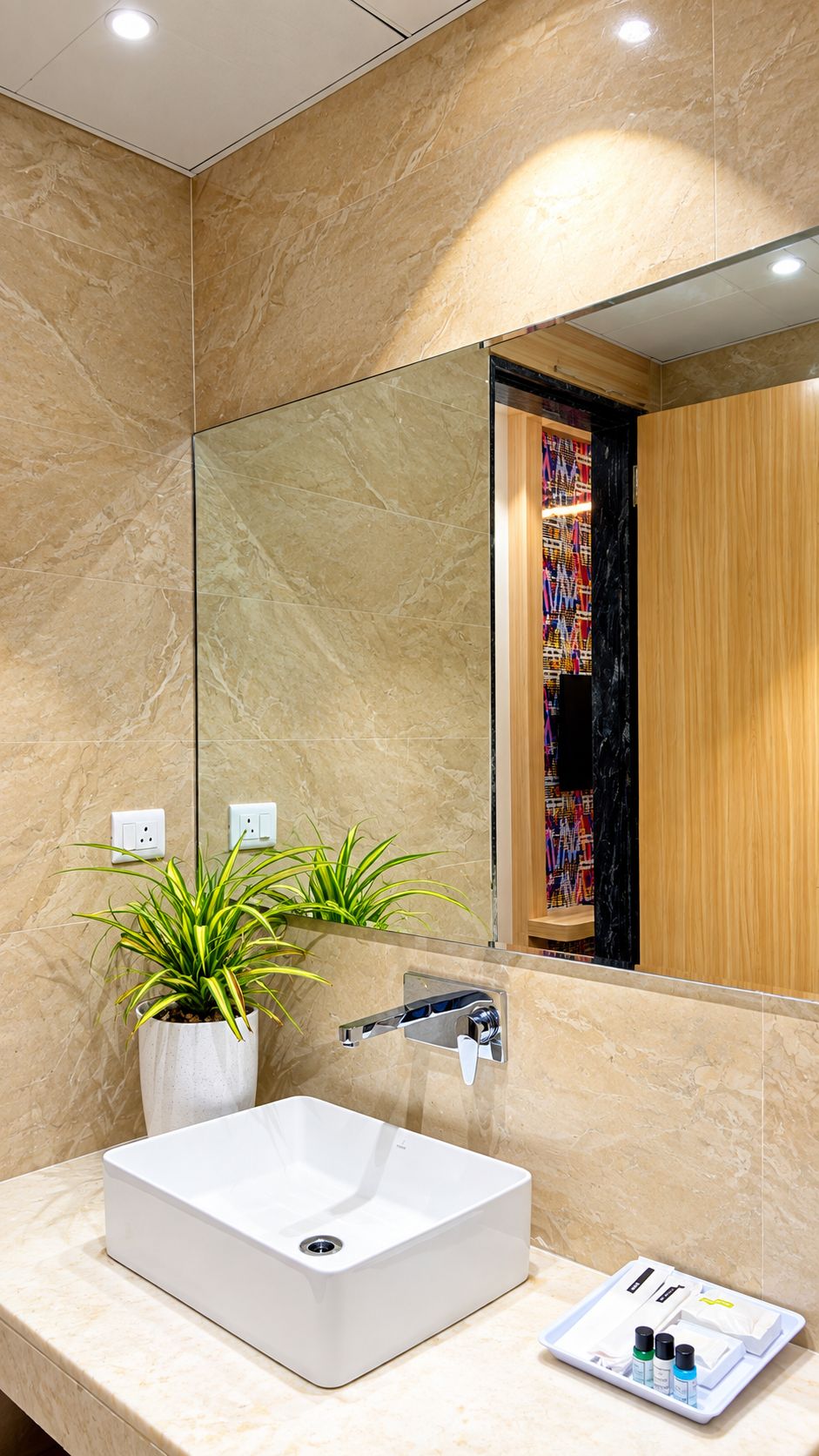 Un baño con un lavabo blanco, un espejo y una planta en maceta.
