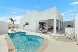 A modern villa with a swimming pool, outdoor seating, and a patio area. - 3BR Villa w/ Private Pool & Patio • Aruba Getaway (Noord)