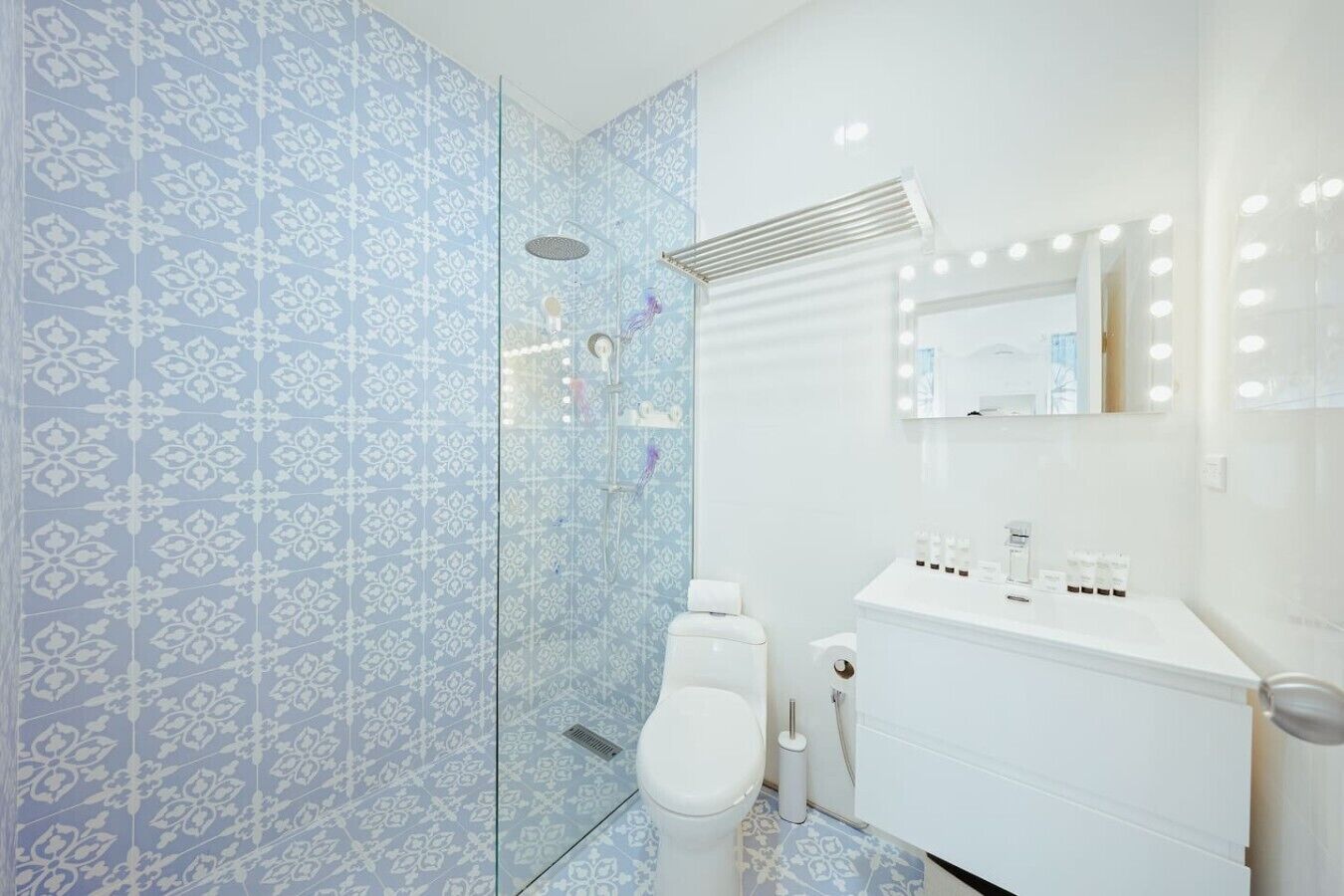 A bathroom with a shower, toilet, and sink with a mirror above.