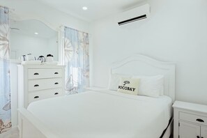 A white bedroom with a bed, a nightstand, a dresser, and a mirror. - 3BR Villa w/ Private Pool & Patio • Aruba Getaway (Noord)