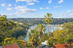 A coastal town with a marina, residential buildings, and lush greenery. - Breathtaking Luxury 2BR | 10 Min CBD | Water Views (Cammeray)