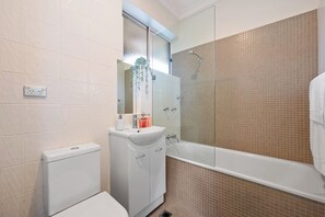 A bathroom with a toilet, sink, and bathtub. - Breathtaking Luxury 2BR | 10 Min CBD | Water Views (Cammeray)