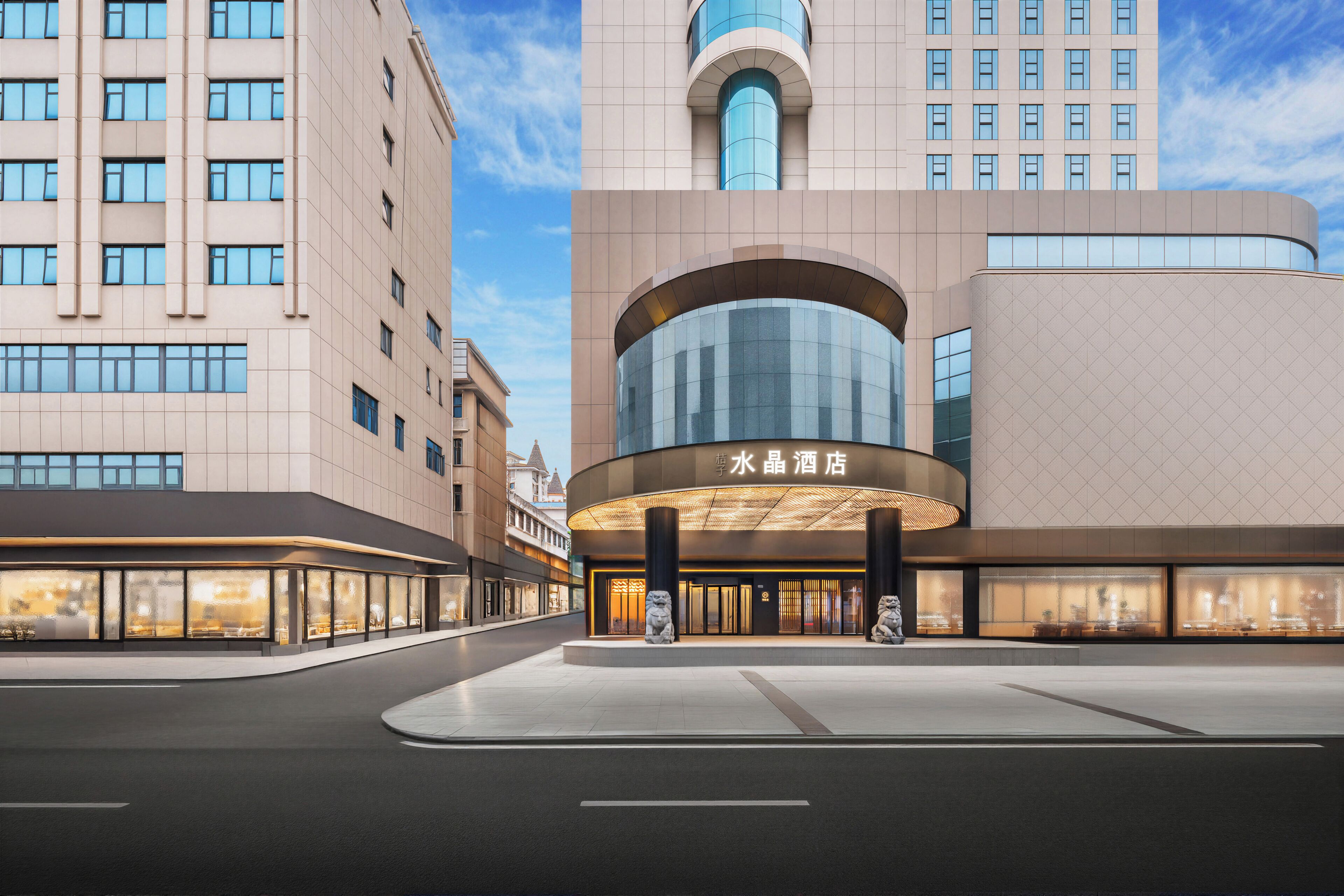 A modern hotel with a curved entrance, large windows, and a prominent sign.